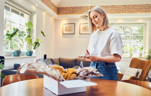 Kobieta przygotowująca zwrot paczki w salonie